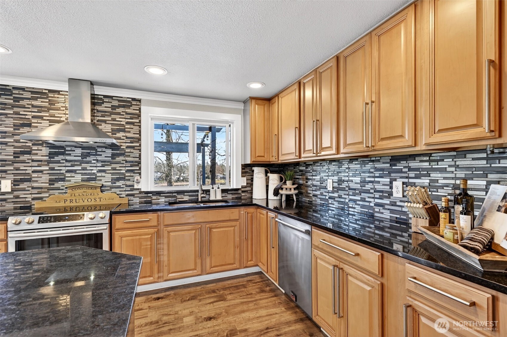 Chef-style kitchen with expansive island, granite counters, mosaic backsplash, and abundant cabinetry for effortless hosting.