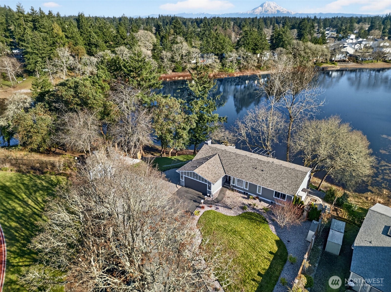 Lake-view kitchen with granite island, mosaic backsplash, and sliding doors to the deck.