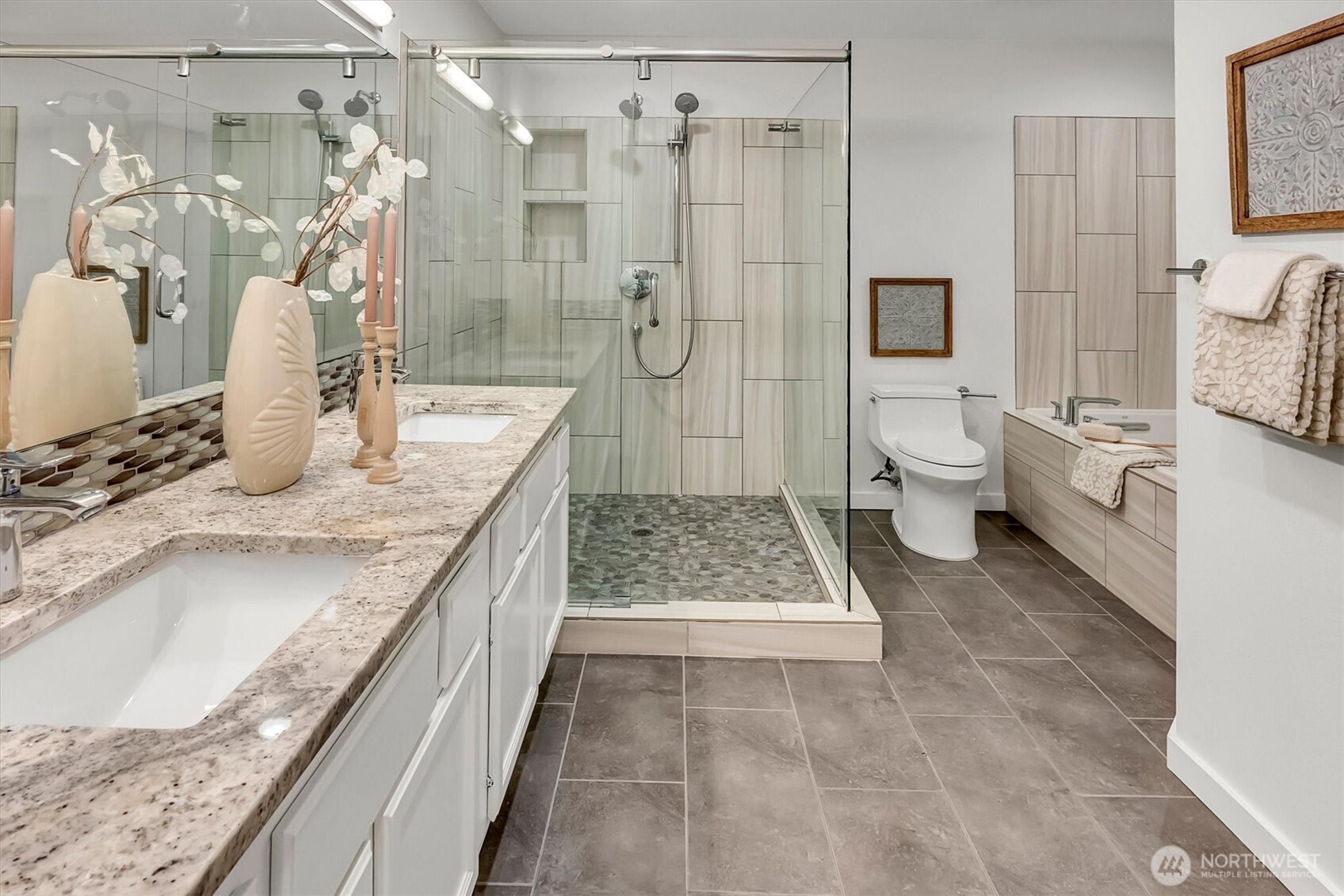 The primary en'suite bath remodel includes....double vanity w/custom tile floors, backspace, shower floor and quartz counter tops. Glorious custom shower + jetted tub. This bathroom feels like your own private + perfectly appointed spa!