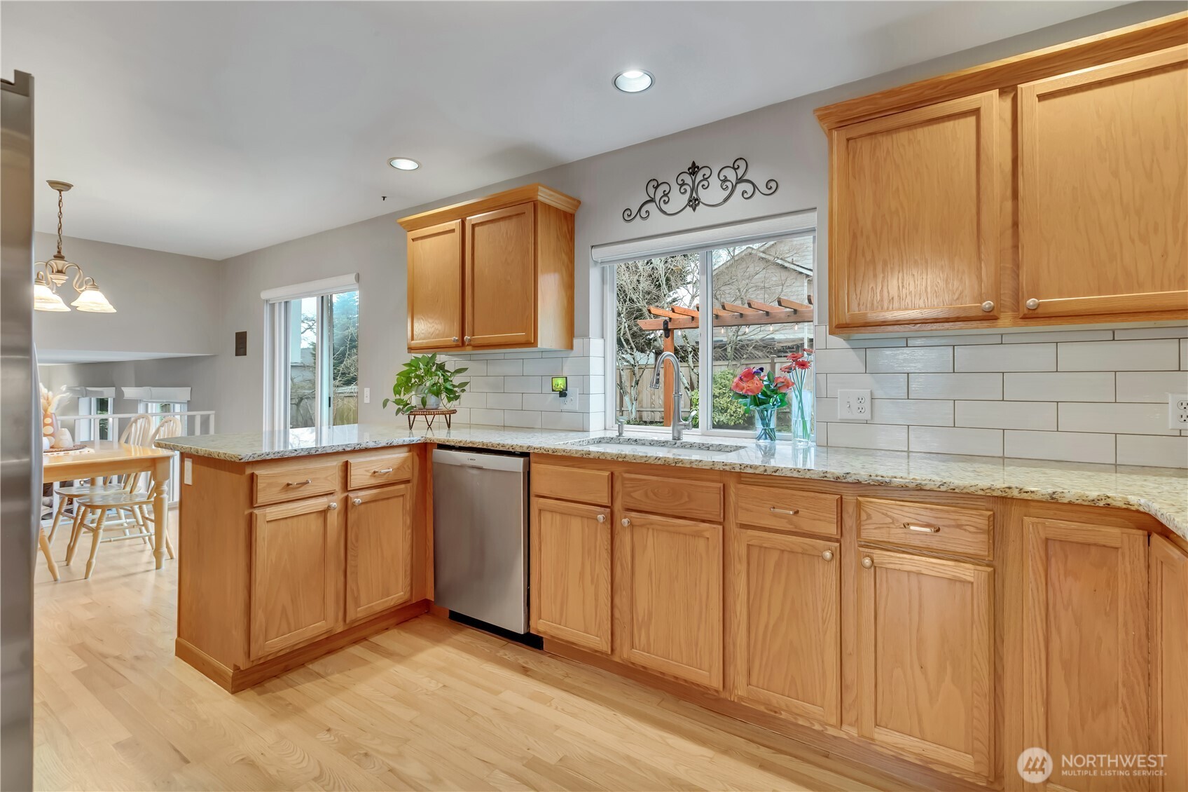 Granite counters, stainless steel appliances, and subway tile backsplash all add warmth and style to the well designed kitchen.