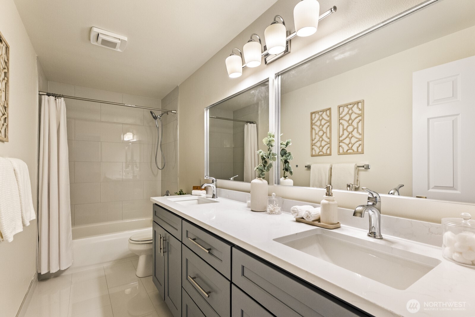 Updated hall bathroom with double under mount sinks, quartz counter, new toilet and tiled floor.