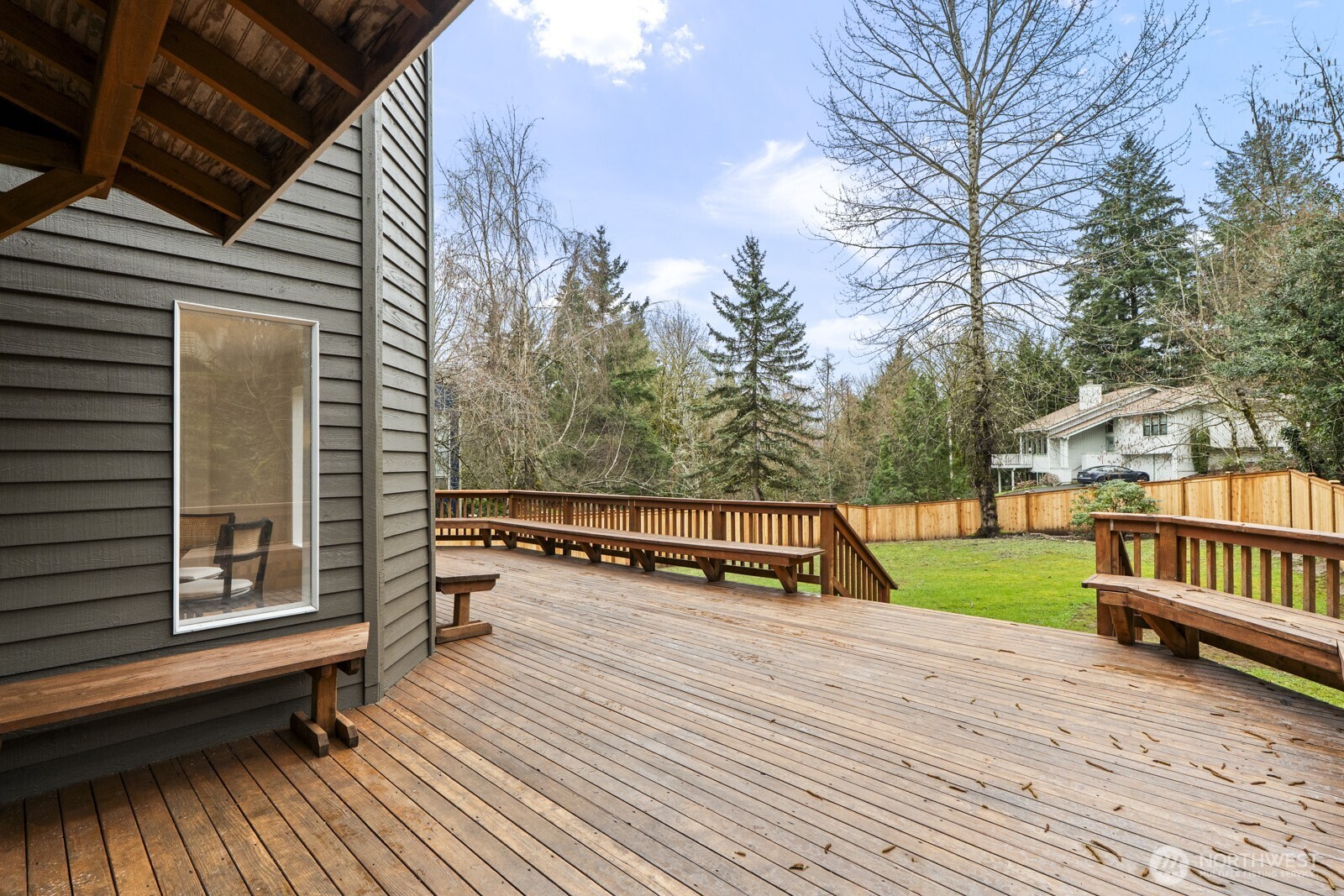 Entertaining sized deck with overhang off the kitchen and family room.