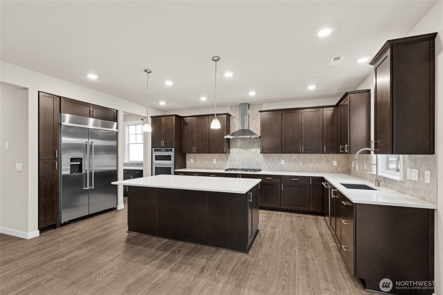 Well-appointed kitchen with gas cooktop, 48" counter depth side-by-side built in refrigerator.  Plenty of space to entertain, home for sale includes white cabinetry.