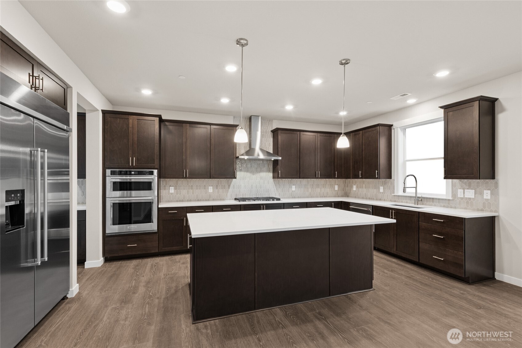 Well-appointed kitchen with gas cooktop, 48" counter depth side-by-side built in refrigerator.  Plenty of space to entertain, home for sale includes white cabinetry.