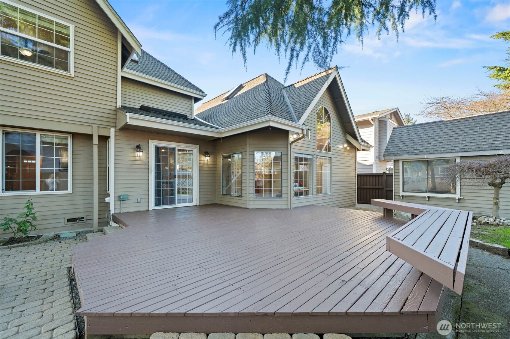 Bright bedroom featuring wainscoting detail and an oversized window.