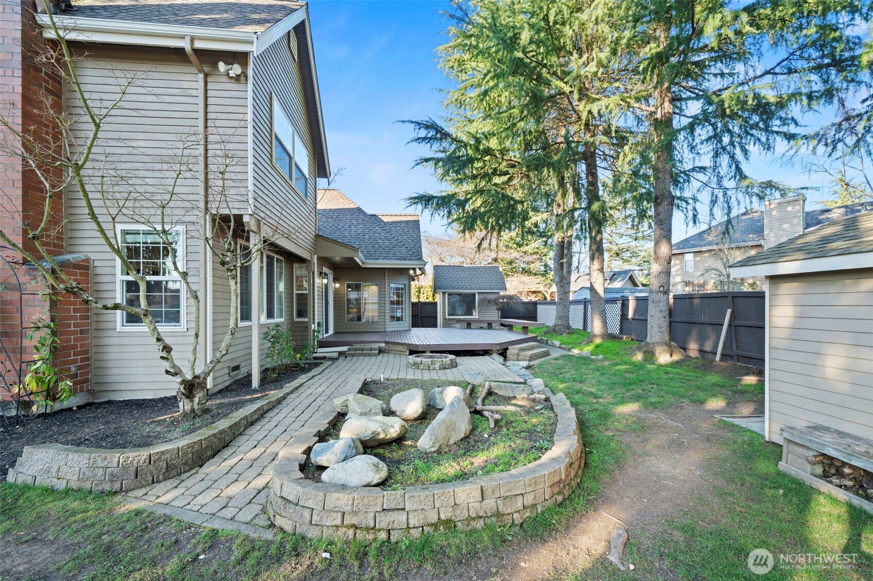 Elevated deck off the rear of the home with access to patio and yard.