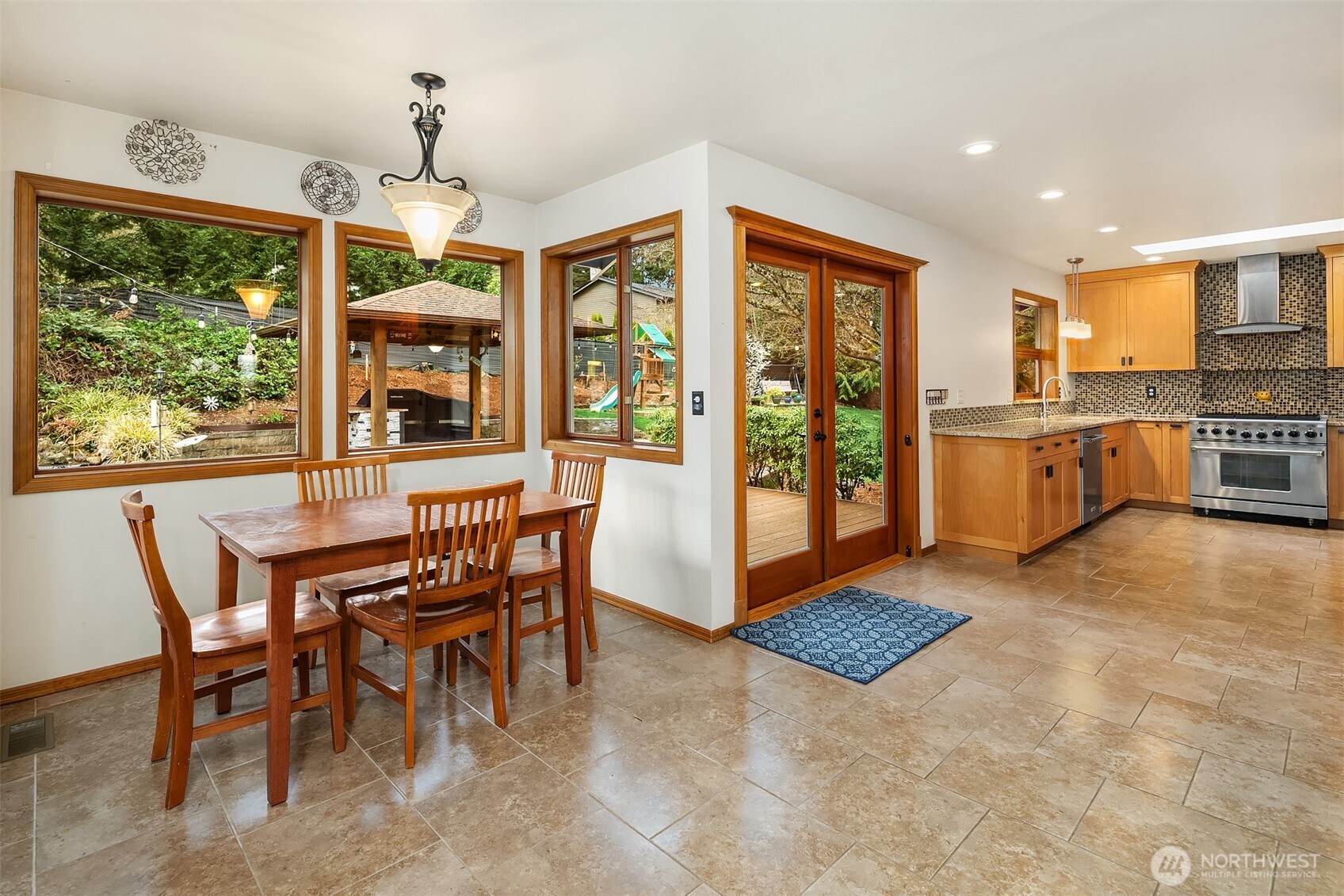 Eating nook and kitchen with the doors to the outdoor kitchen and yard.