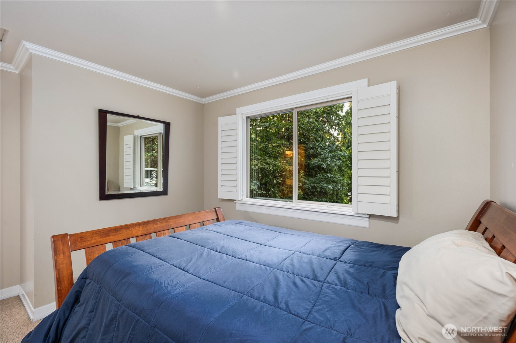 Relax in the deep soaking tub framed by classic plantation shutters and a neutral color palette.