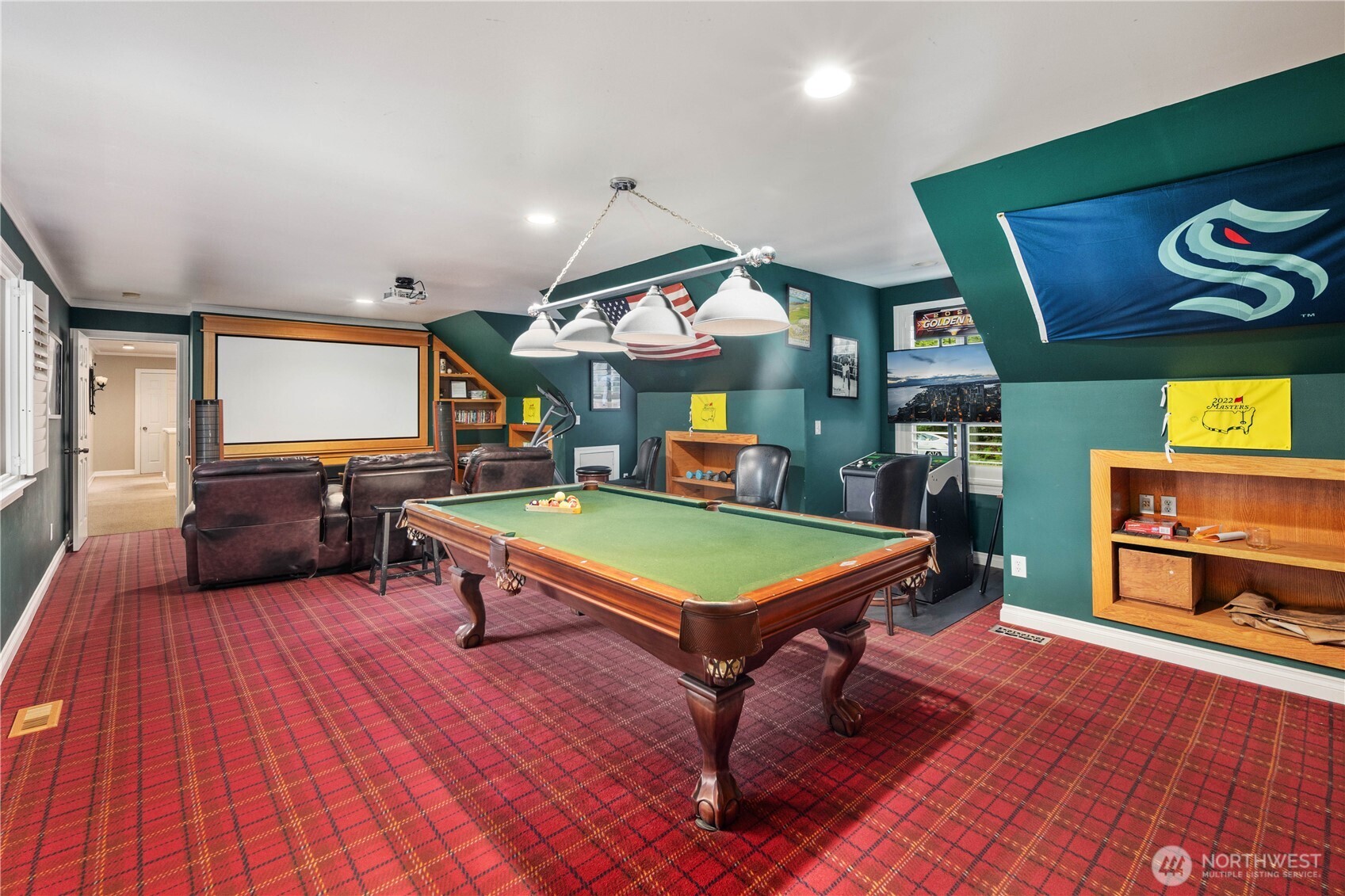 Spacious recreation room perfect for movie nights, featuring cozy leather seating and garden views.