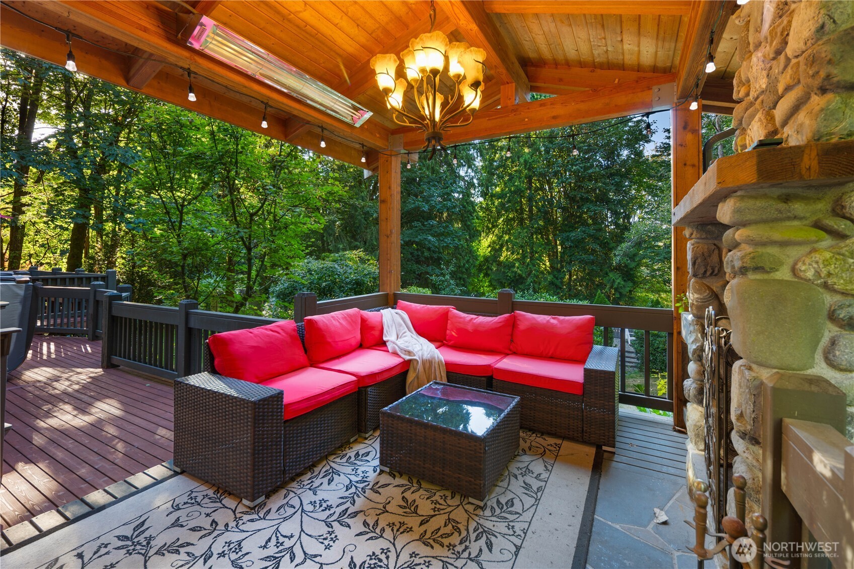 Sun-drenched dining deck overlooking the lush forest, perfect for summer BBQs and alfresco meals.