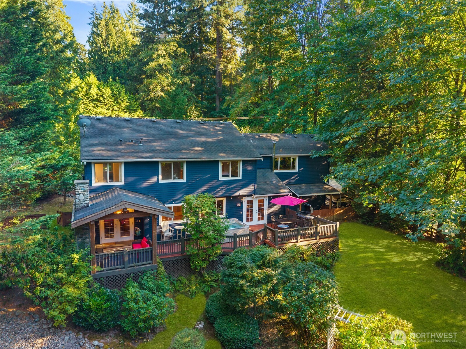 Host in style with this grand floor-to-ceiling stone fireplace under a custom timber-framed cover.