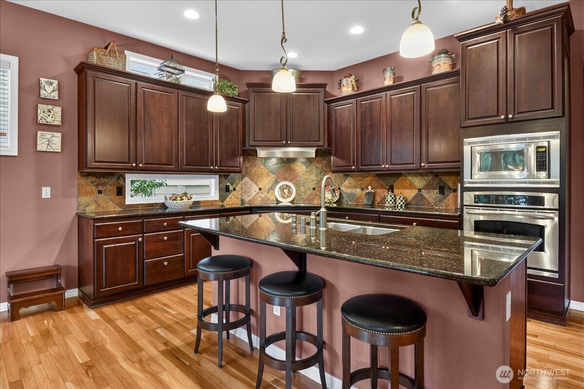 Imagine lunch or a card game next to this three-sided gas fireplace and gazing through the single light French Doors at the golf course and green forest beyond.