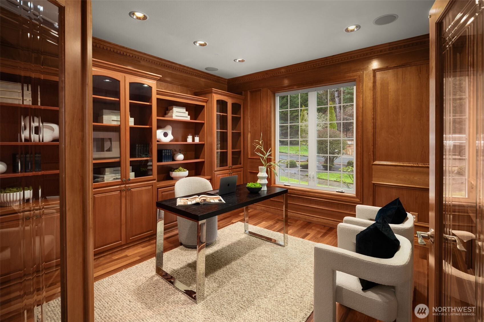 Library-style office with rich wood cabinetry and built-in shelving.