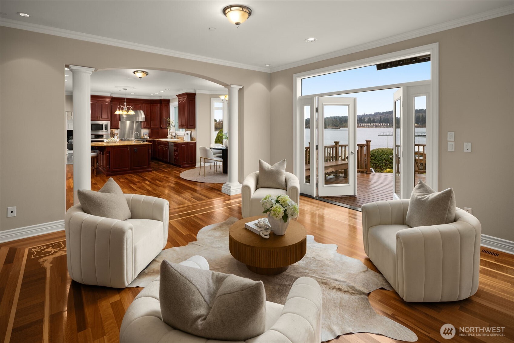 Living spaces flow seamlessly toward the kitchen and waterfront deck.