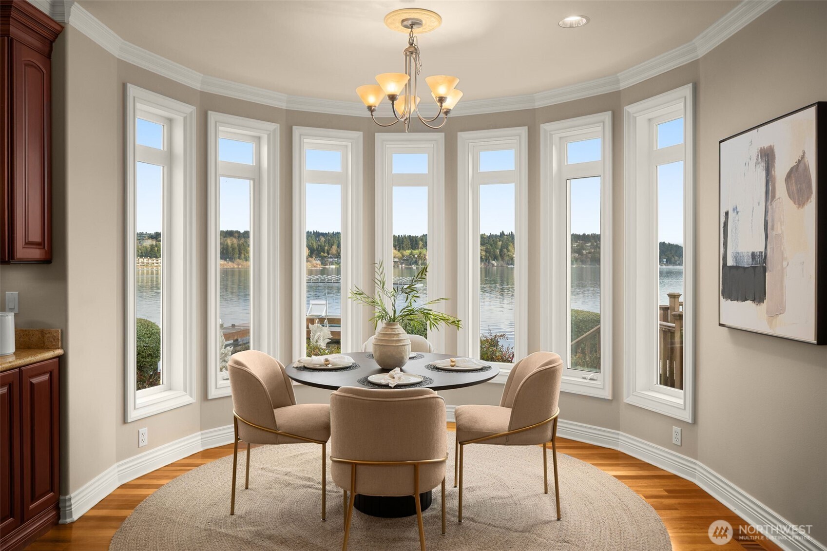 Lake-filled dining nook framed by a wall of windows overlooking the lake.