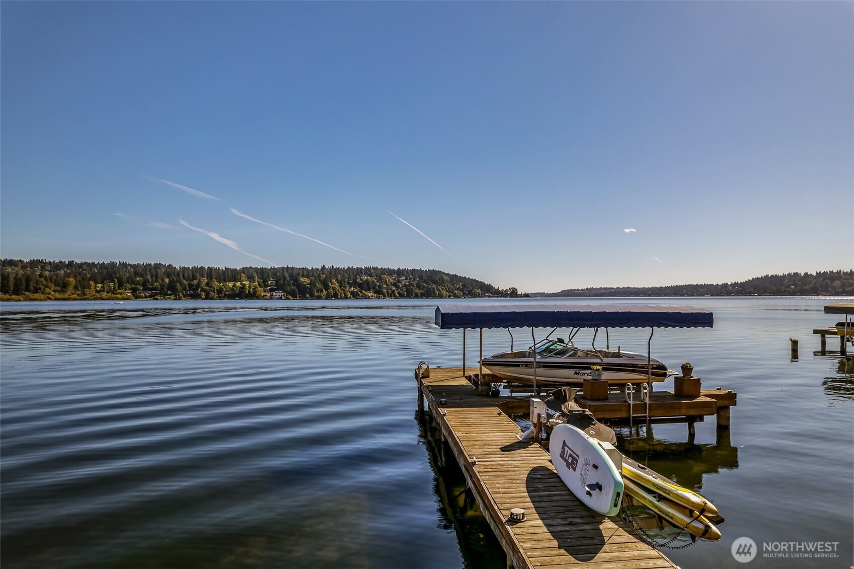 On a sunny day, the lake sparkles just beyond your backyard, where a private dock and calm waters invite afternoons of boating, paddle boarding, and quiet moments by the shoreline. Cover currently removed