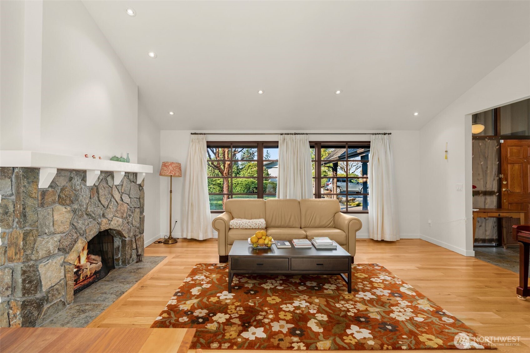 Living room features a stunning, stone fireplace and wide-plank white oak hardwoods.