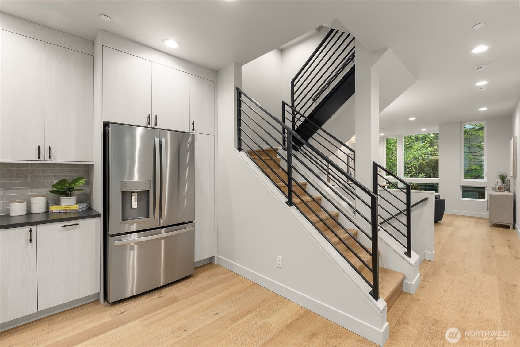 Modern staircase with glass railings creates a seamless flow between the home’s multiple levels