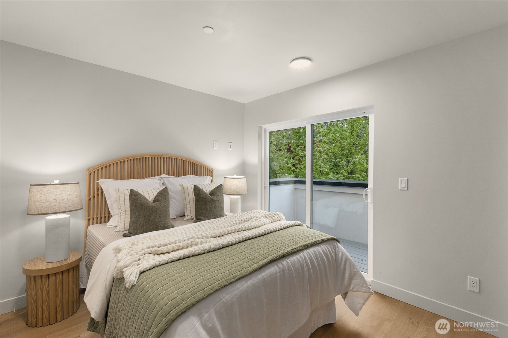 Secondary bedroom featuring private outdoor access and beautiful hardwood flooring.