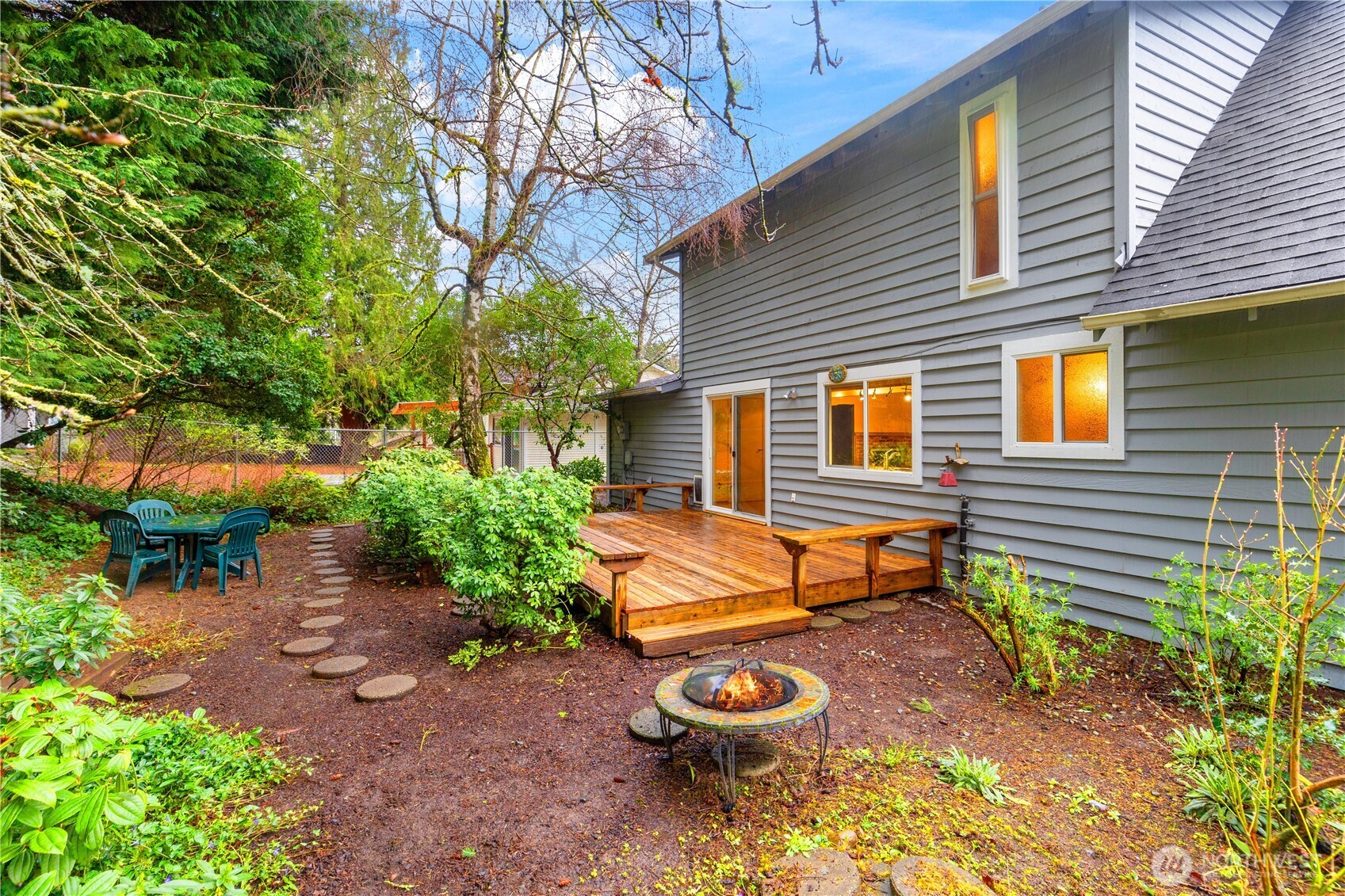Fully fenced backyard features a native plant garden, fire pit, and deck