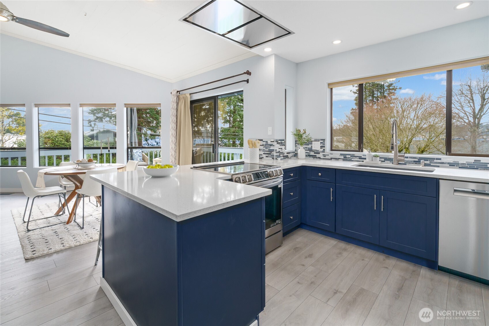 New kitchen with beautiful navy cabinets, quartz, designer tile, induction range, special vent hood flush to the ceiling and coffee bar!