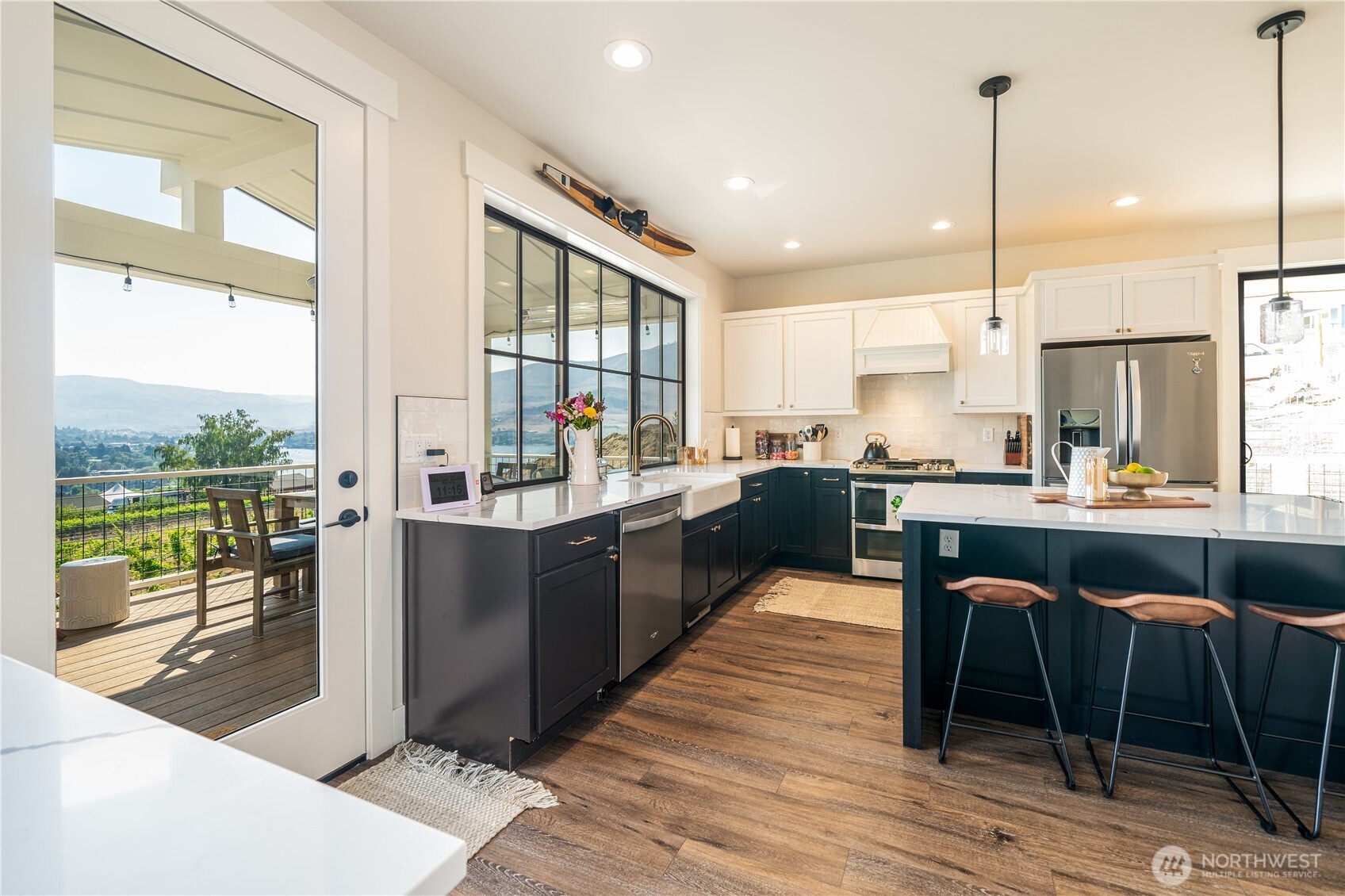 Kitchen with quartz countertops, engineered wood flooring, stainless steel appliances and French doors leaded to the view balcony and outdoor living space with BBQ and dining and lounge areas.