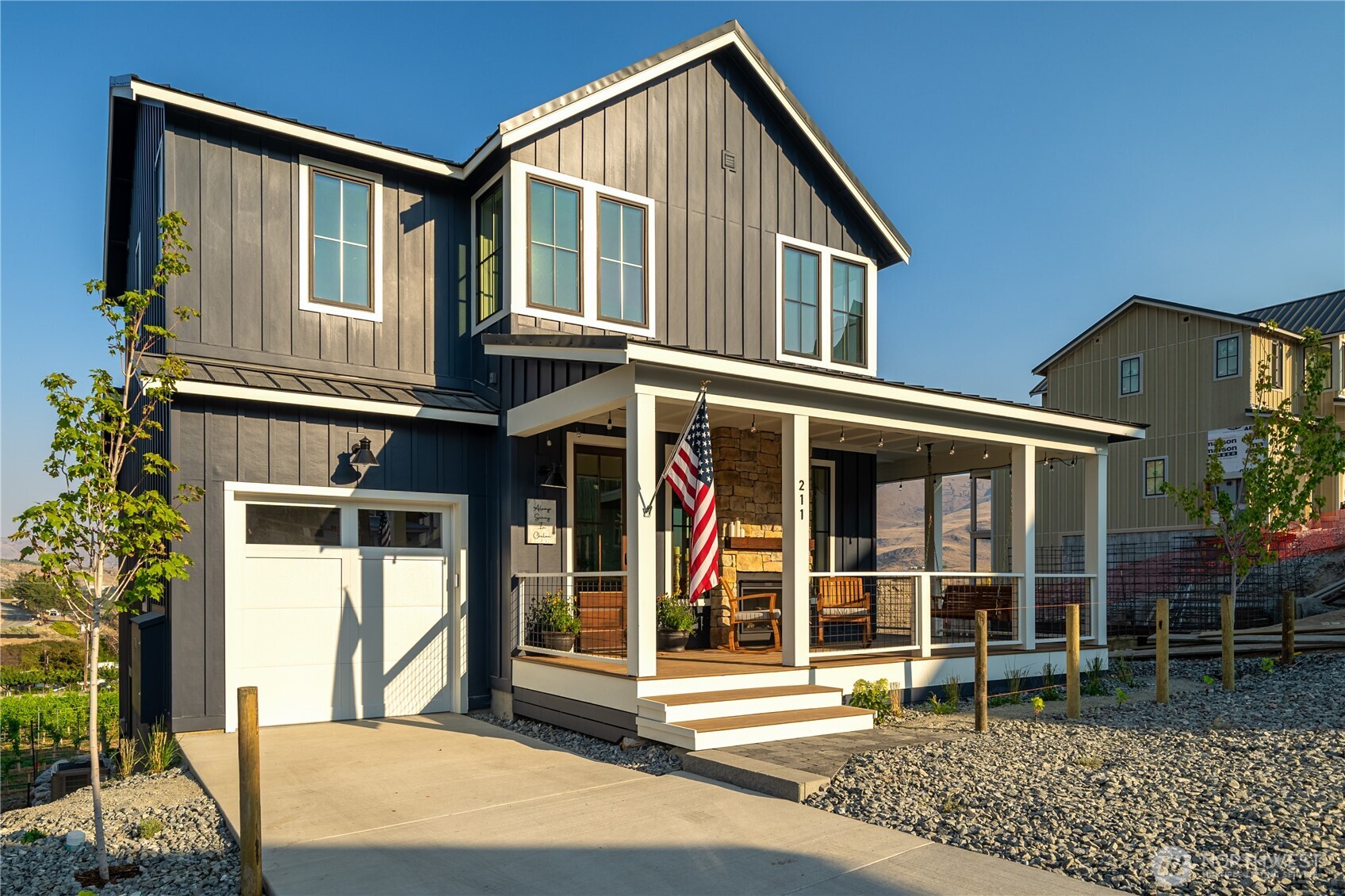 Exterior view with classic wraparound porch and attached 1-car garage.