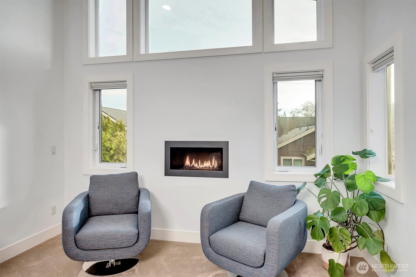 A cozy sitting area with fireplace, and large windows that bring in abundant natural light.