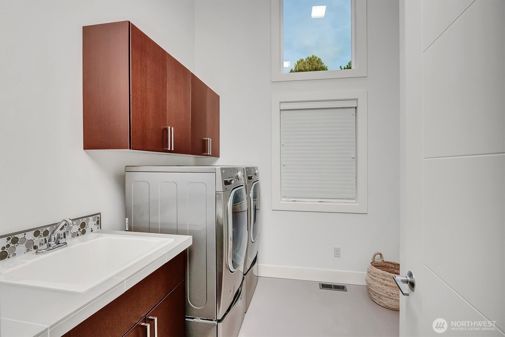 An upper-level laundry room with cabinetry and utility sink add everyday convenience.