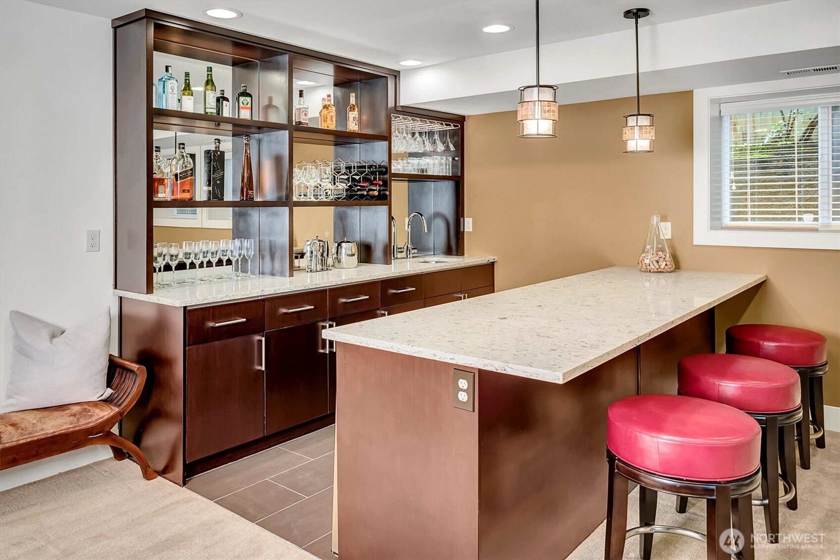Updated with a large wet bar, seating counter, open shelving with glass walls, and a mini-refrigerator.