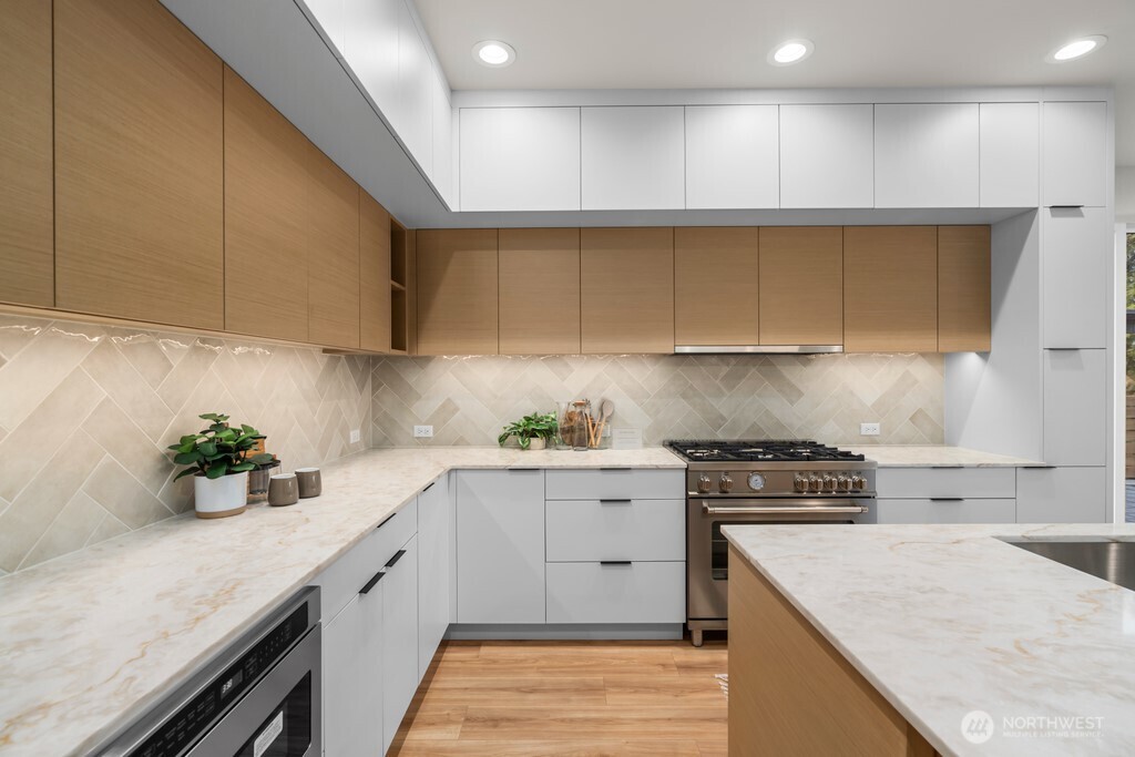 Dreamy modern-minimal kitchen layered in soothing neutrals with flush cabinetry and warm-toned quartz counters.