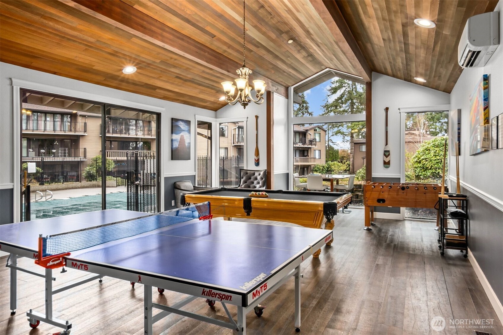 A lively community clubhouse featuring a pool table, ping pong, foosball, air conditioning, and plenty of space to watch the big game—with effortless access to the pool for endless fun and relaxation.
