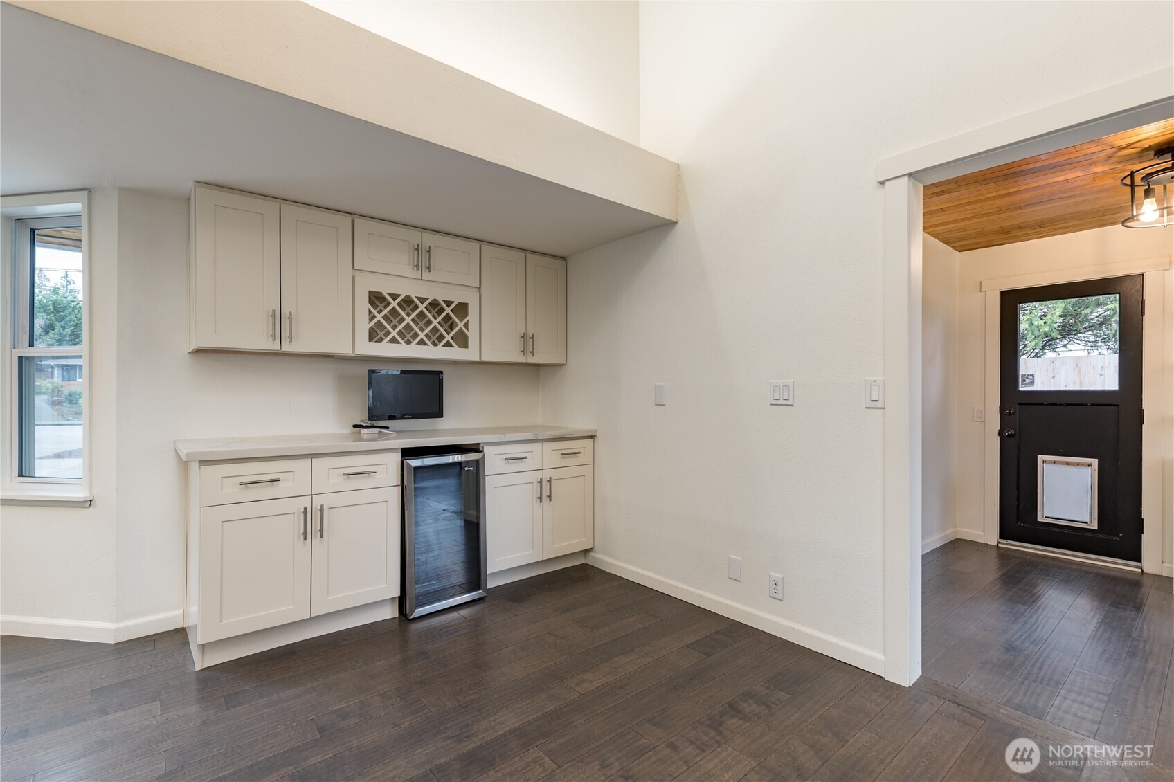 The ultimate home beverage center, featuring a built-in wine rack and mini fridge, is perfectly positioned for easy entertaining