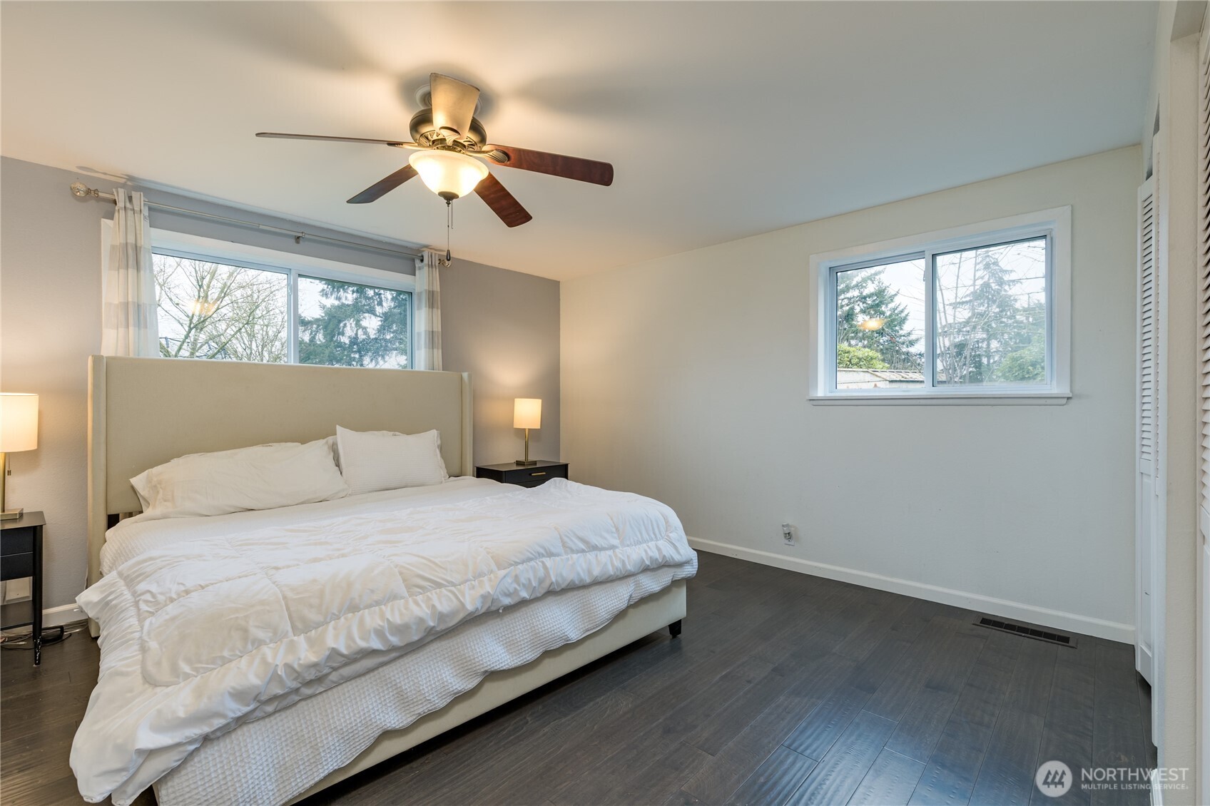Primary bedroom on the main level includes dual closets and rich engineered hardwood flooring