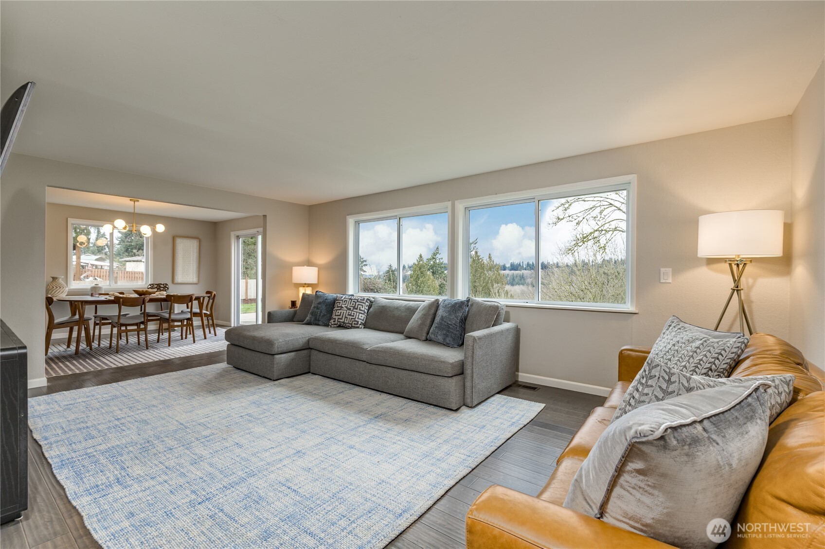 Living room with oversized windows overlooking the expansive back yard