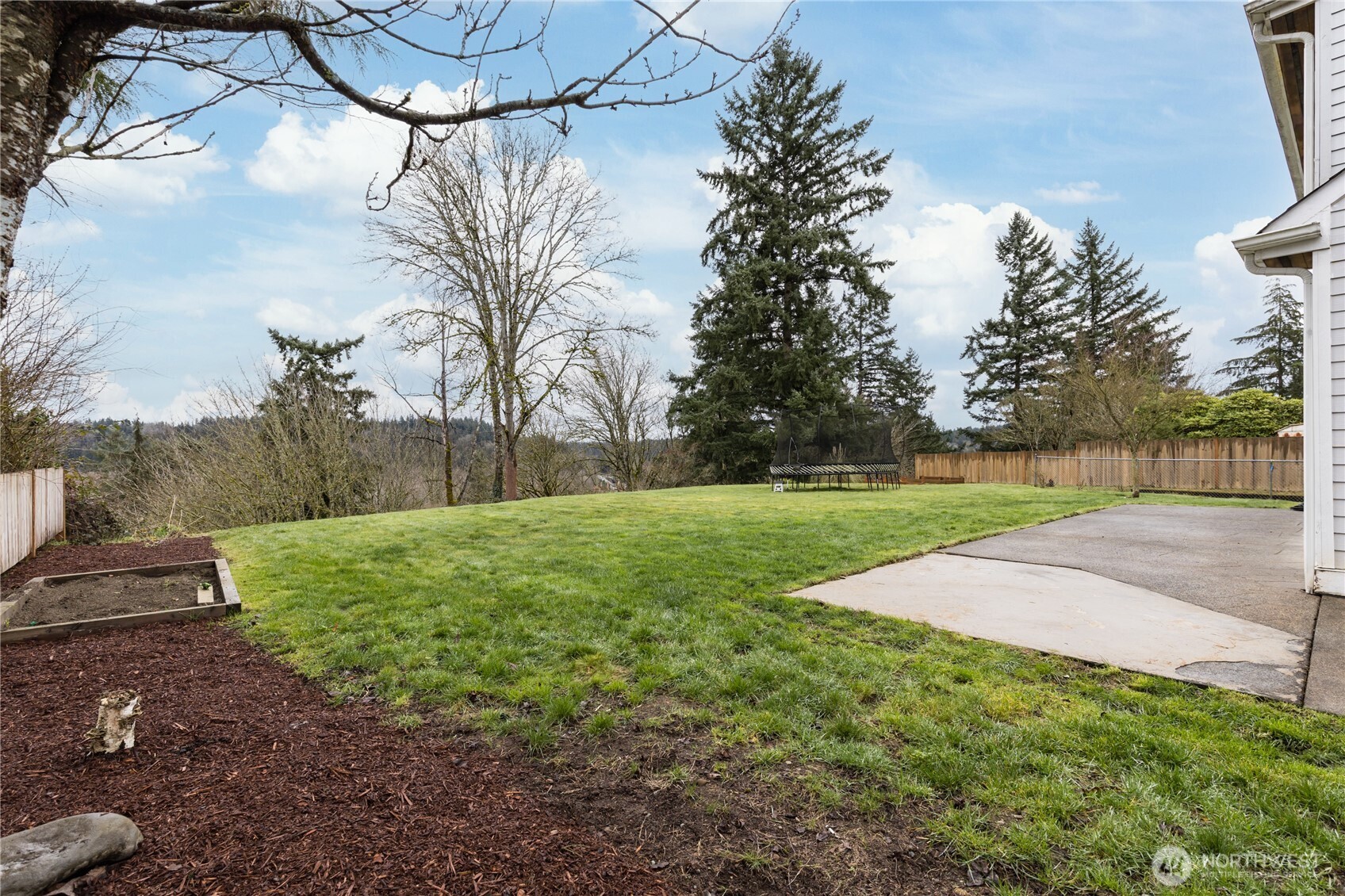 Low-maintenance landscaping meets maximum utility in this large, sun-drenched outdoor space