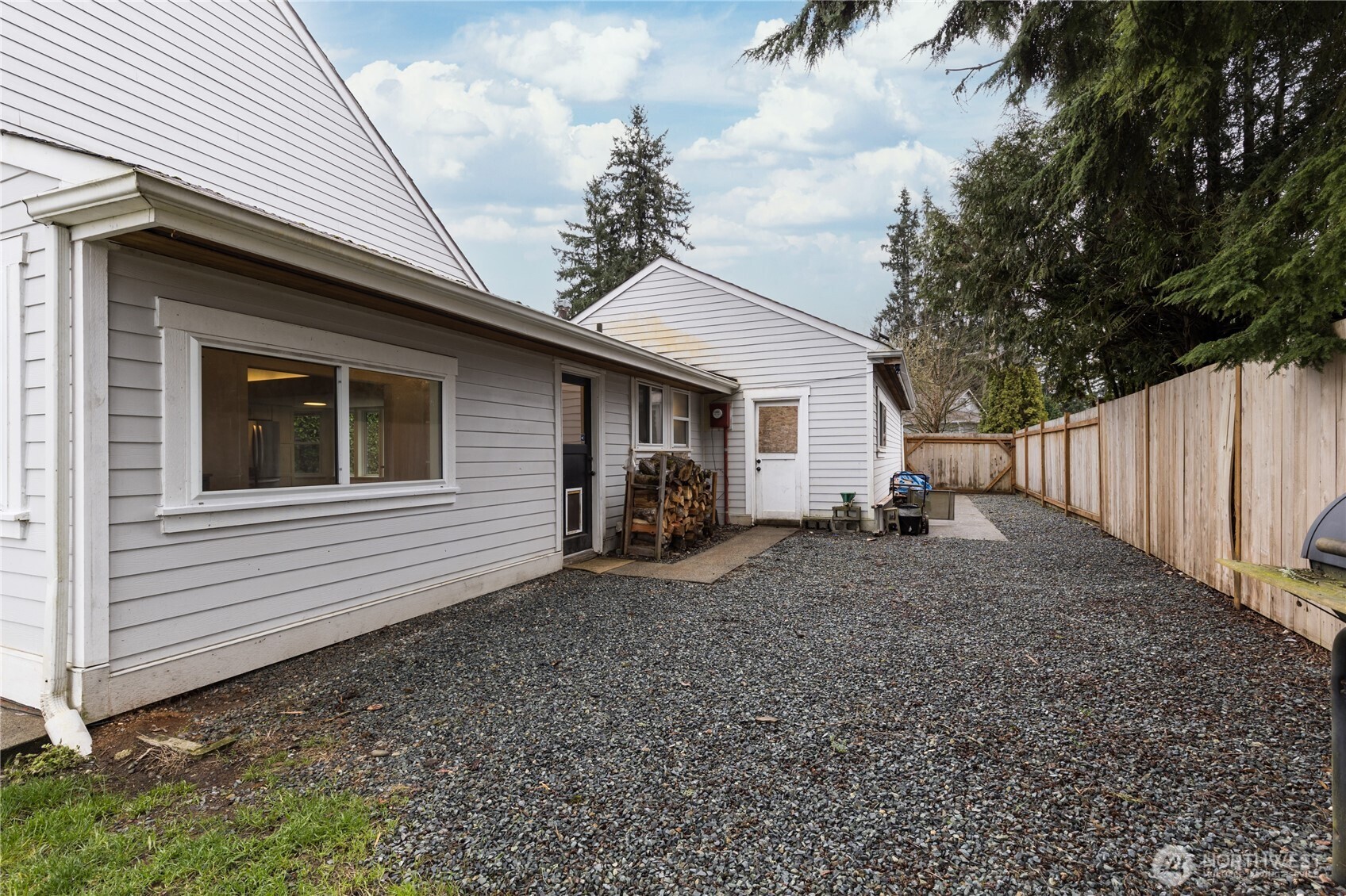 The low-maintenance graveled side yard offers a tidy space for outdoor storage or a dog run