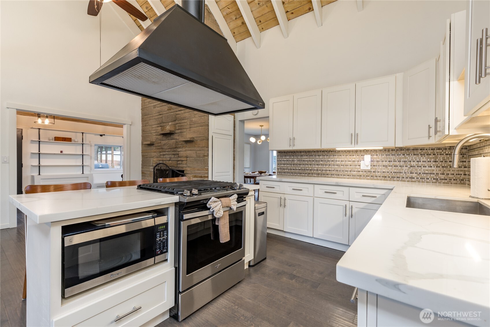 This gourmet kitchen boasts a high-performance gas range and custom ventilation