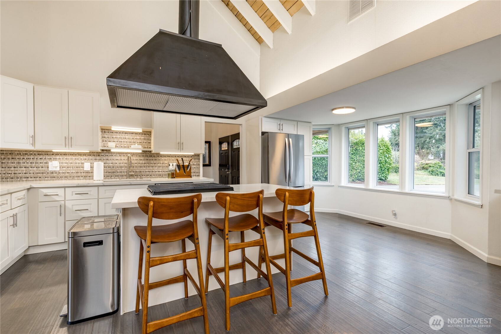Counter seating and breakfast nook next to a bay of windows
