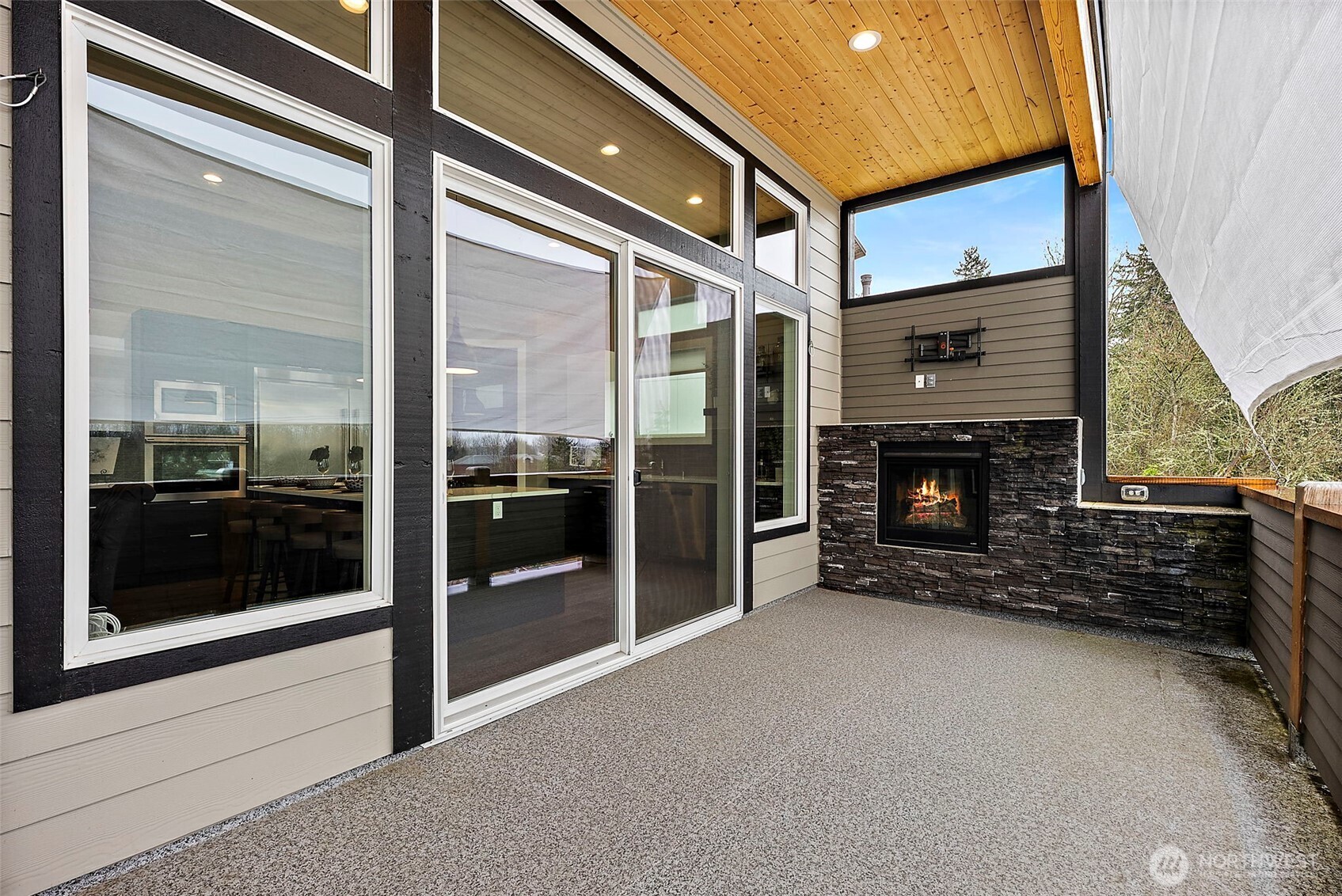The covered balcony offers a comfortable outdoor living space with a built in fireplace and plenty of room for seating and relaxation. Large windows and sliding doors connect the interior living areas to this inviting outdoor entertaining space.