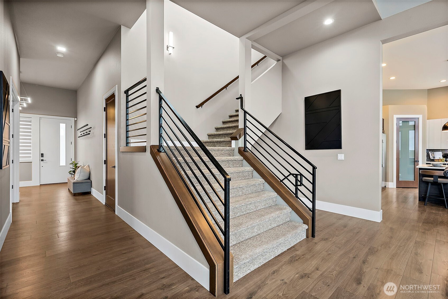 Contemporary staircase with sleek metal railing and open design connecting the main level to the upper floor. The bright layout and modern architectural details add style and flow to this Auburn River Rock home.