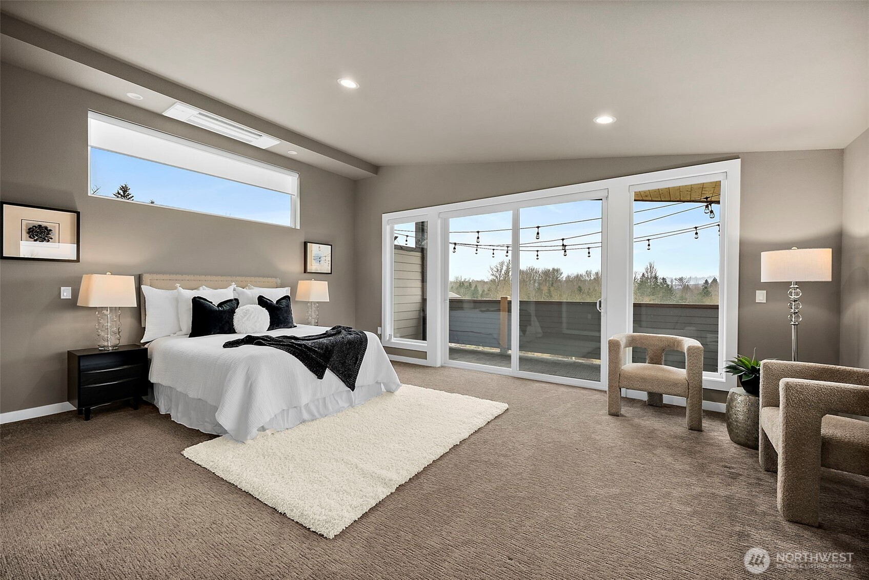 The spacious primary bedroom offers a peaceful retreat with large sliding glass doors that bring in natural light and open to a private balcony. The layout provides generous space for relaxation while enjoying the quiet surroundings of this Auburn, Washington home.