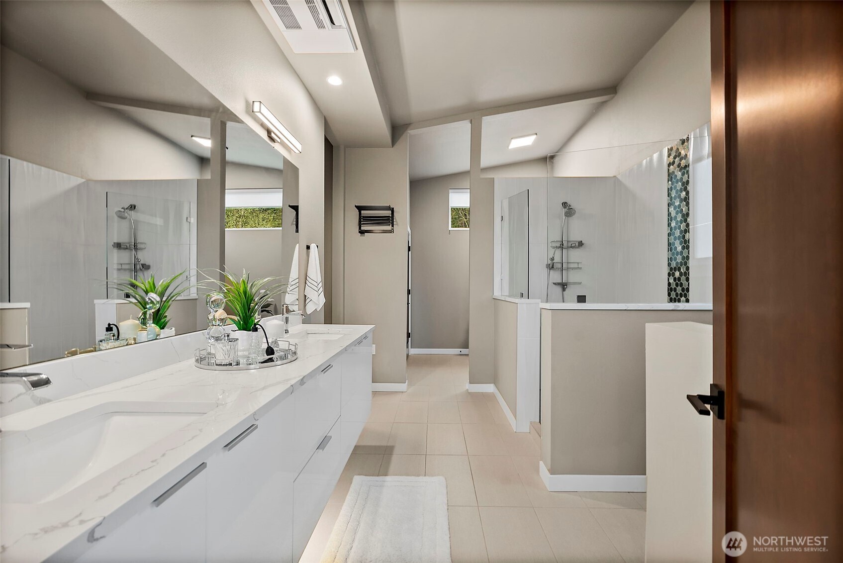 Primary bathroom in this River Rock home in Auburn features a spa style layout with dual vanity, modern finishes, walk in shower, and a freestanding soaking tub. The bright and spacious design creates a relaxing retreat with clean lines and contemporary comfort.