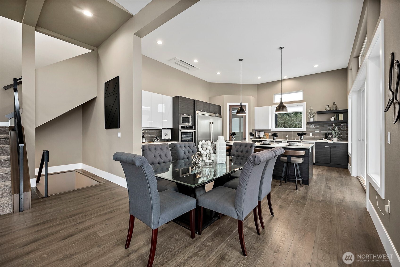Dining area in this River Rock home features an open concept layout with large windows, modern lighting, and seamless flow into the kitchen and living space. The bright setting and spacious design create an inviting area for everyday meals and entertaining.