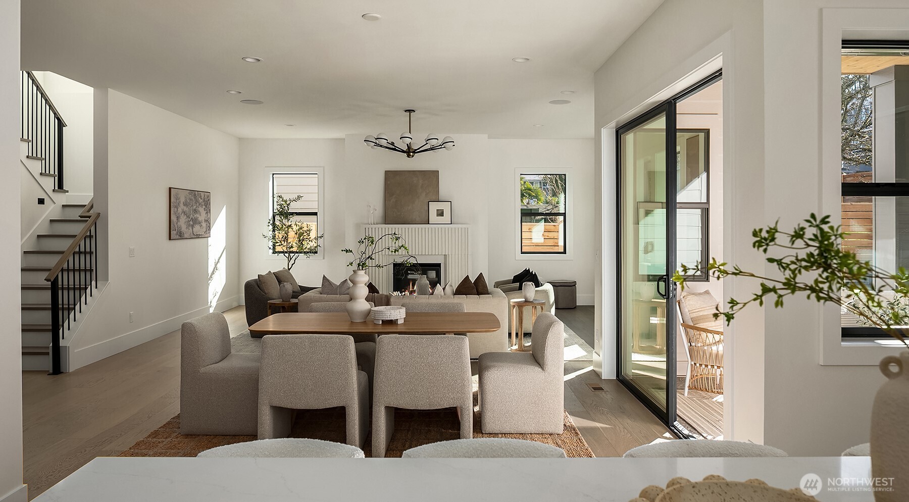 The stunning great room features soaring 10-foot ceilings, abundant natural light, and a dramatic sculptural fluted fireplace that anchors the space with architectural elegance.