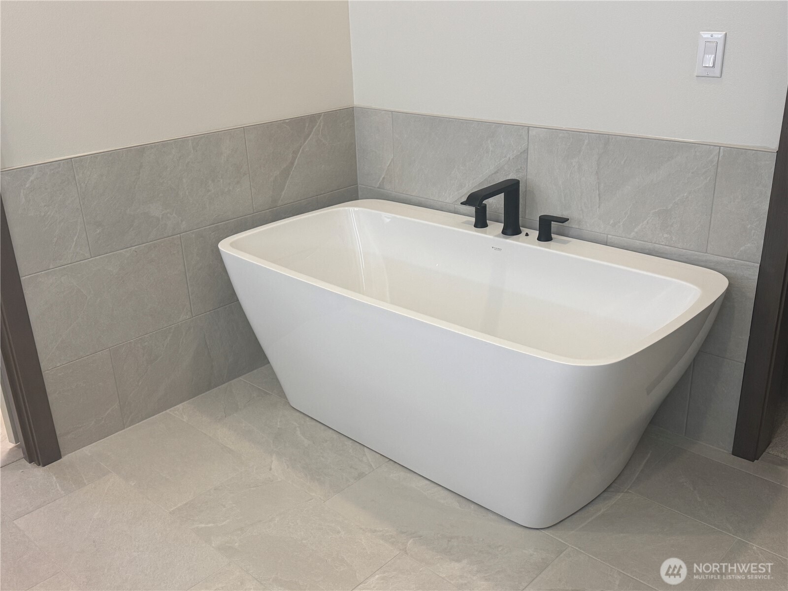 Primary Suite bath.  offers tile floors and direct access to walk in closet and laundry room.