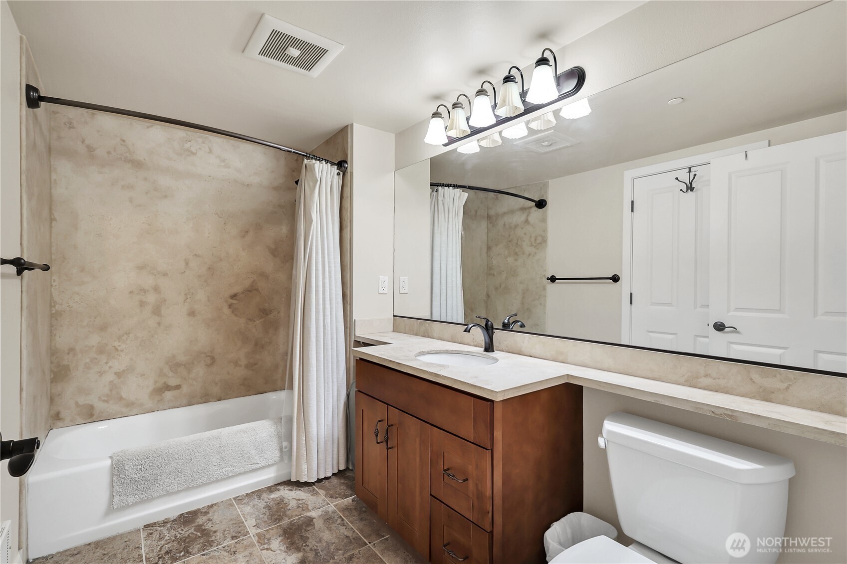 Ceramic tile floors, limestone countertops, tub/shower combination with no grount, slab surround.