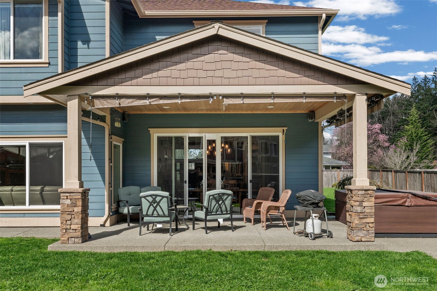 Covered outdoor living area with space for seating and year-round entertaining. Wired in speakers.