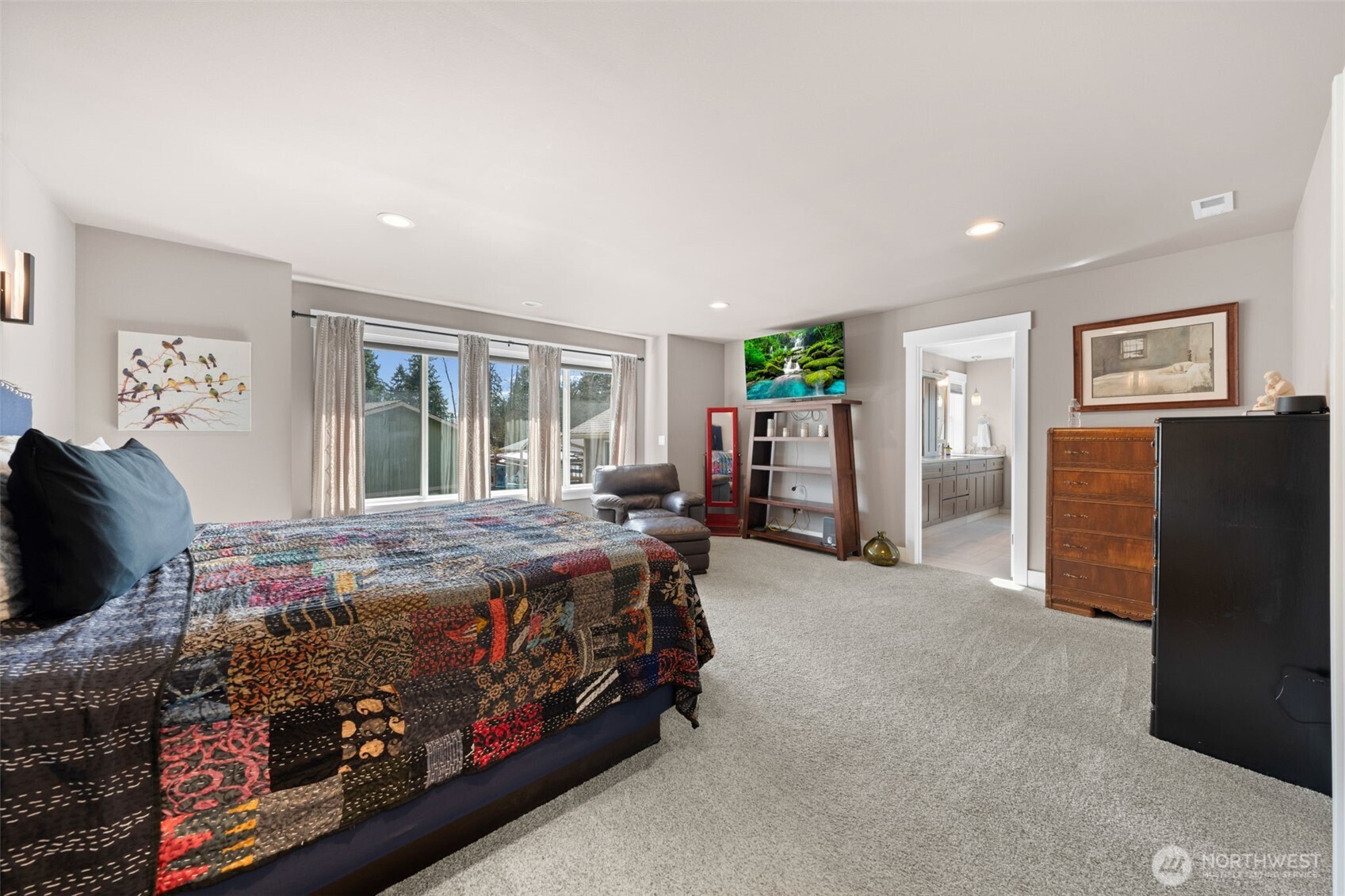 Generous primary suite with sitting area and large windows and primary bathroom