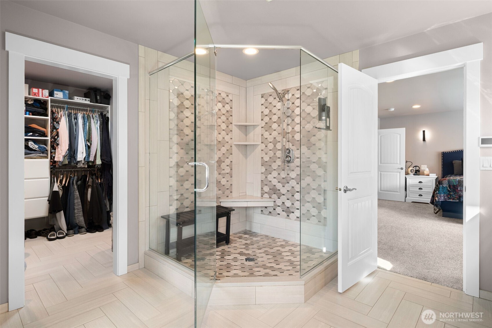 Luxury primary bath featuring a large walk-in shower, open layout, and walk in closet.